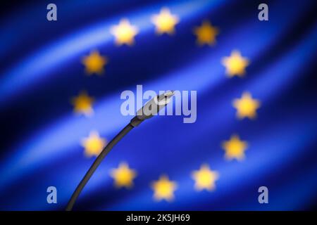 Warschau, Polen. 05. Oktober 2022. Ein USB-C-Kabel mit der EU-Flagge im Hintergrund ist auf diesem Bild am 05. Oktober 2022 in Warschau, Polen, zu sehen. Die EU hat am Dienstag ein Gesetz verabschiedet, das USB-C als Standard für das Laden von Ports auf elektronischen Geräten ab 2024 durchgesetzt hat. Der Umzug ist besonders kritisch für Apple, das seit Jahren an seinem proprietären Lightning-Ladezubehör für sein beliebtes iPhone festgehalten hat. (Foto: Jaap Arriens/SIPA USA) Quelle: SIPA USA/Alamy Live News Stockfoto