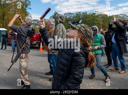 Greeley, Usa. 08. Oktober 2022. Die Teilnehmer des Rod of Iron Freedom Festivals sehen zu, wie das Patriot Fallschirmteam landet. Das Rod of Iron Freedom Festival ist eine dreitägige Veranstaltung, bei der die zweite Änderung gefeiert wird. Rev. Sean Moon von der Unification Church veranstaltet die Veranstaltung im Tommy Gun Warehouse, die Teilnehmer können auf einem Waffenlager schießen, eine Waffenauktion wird abgehalten, Referenten und eine Waffenlager-Modenschau sind alles Highlights. Kredit: SOPA Images Limited/Alamy Live Nachrichten Stockfoto