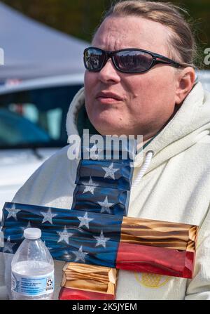 Greeley, Usa. 08. Oktober 2022. Beim Rod of Iron Festival hält eine Frau ein Kreuz, das mit einem Motiv der amerikanischen Flagge gemalt ist, in ihrer Nähe. Das Rod of Iron Freedom Festival ist eine dreitägige Veranstaltung, bei der die zweite Änderung gefeiert wird. Rev. Sean Moon von der Unification Church veranstaltet die Veranstaltung im Tommy Gun Warehouse, die Teilnehmer können auf einem Waffenlager schießen, eine Waffenauktion wird abgehalten, Referenten und eine Waffenlager-Modenschau sind alles Highlights. Kredit: SOPA Images Limited/Alamy Live Nachrichten Stockfoto