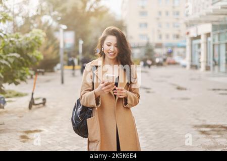Lifestyle-Porträt hübsche asiatische kasachische Frau mit Telefon auf der Straße Stockfoto