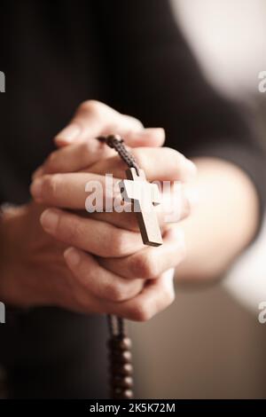 Getreu seiner Religion. Die Hände umklammten und hielten einen Rosenkranz im Gebet. Stockfoto