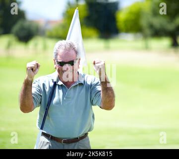 Viel zu tun. Porträt eines begeisterten und siegreichen älteren Golfspielers, der seine Fäuste mit einem Lächeln auf den Lippen hält. Stockfoto