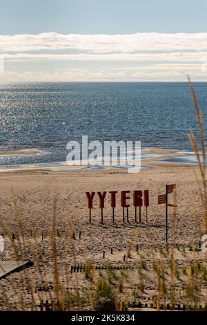 Yyteri Beach und Sanddünen am Ufer der Ostsee in Pori, Finnland, mit rotem Yyteri-Schild, eingerahmt von unfokussierten Gräsern Stockfoto