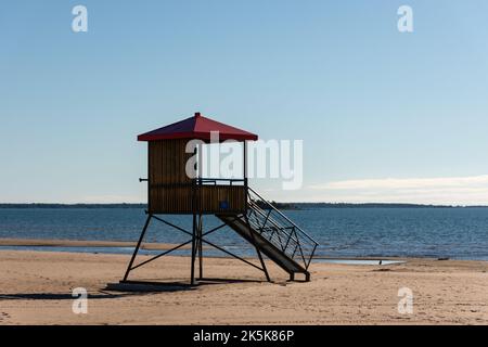 Hölzerner Rettungsschwimmer-Turm mit rotem Dach am Sandstrand von Yyteri in Pori, Finnland, mit klarem blauen Himmel im Hintergrund Stockfoto