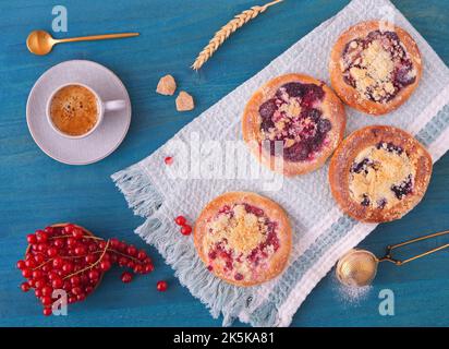 Nahaufnahme von Kuchen mit Sommerfrüchten, Johannisbeeren, Pflaumen, Brombeeren, Blaubeeren und Krümel, Blauer Holztisch, hoher Sichtwinkel, flach liegend, t Stockfoto