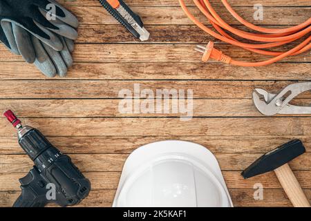 Flache Lay-Komposition mit verschiedenen Bauwerkzeugen auf Holzhintergrund. Stockfoto
