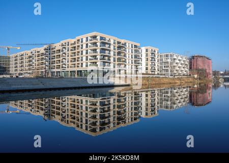 Moderne Mehrfamilienhäuser mit einer perfekten Reflexion in einem kleinen Kanal in Berlin, Deutschland gesehen Stockfoto