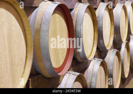 Fässer voller Wein. Fässer mit Wein aneinander gestapelt. Stockfoto