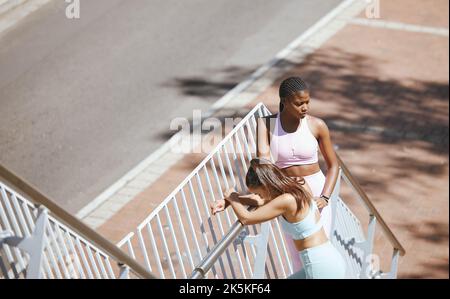 Frauen, müde und entspannen Sie sich im Treppentraining, Training und Bewegung in New York City für Gesundheit, Wellness und Herz-Herz-Kreislauf. Freunde, Läufer und Sport Stockfoto