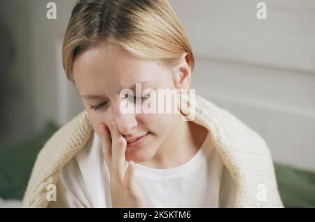 Ein ungesundes Mädchen mit einer verstopften Nase verwendet ein Nasenspray, um eine Erkältung zu behandeln. Medikamente gegen verstopfte Nase und Allergien Stockfoto