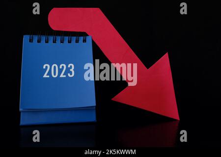 Jahr 2023 Finanzkrise, Rezession und Börsencrash-Konzept. Selektiver Fokus des Kalenders 2023 mit nach unten gerot Pfeil in dunkelschwarz Stockfoto