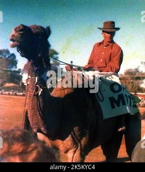 Ein altes Schnappschuss-Foto, das von einem Kamel und seinem Reiter beim Camel Cup in Alice Springs, Australien, aufgenommen wurde Stockfoto