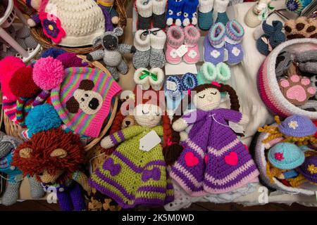 Attraktive Mischung aus handgestrickten Neuheiten und Hüten zum Verkauf im Royal Oak Pub Laxfield in Suffolk Stockfoto