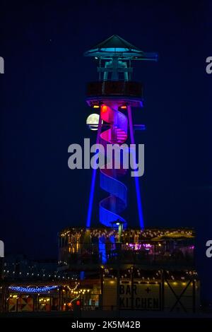 Brighton, East Sussex, England. 08. Oktober 2022. Ein (97,5%) Vollmond erhebt sich über dem Strand in Brighton und wird hier hinter dem Reißleine vom Brighton Pier aus gesehen glühend gesehen.©Sarah Mott / Alamy Live News. Stockfoto