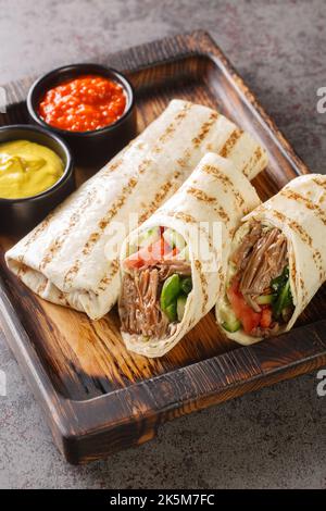 Durum Döner Lavasch Shaurma Fleisch Nahaufnahme auf dem Holzbrett auf dem Tisch. Vertikal Stockfoto