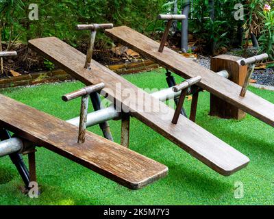 Set von alten leeren hölzernen Wippe auf dem grünen Hof auf dem Spielplatz im Garten. Stockfoto