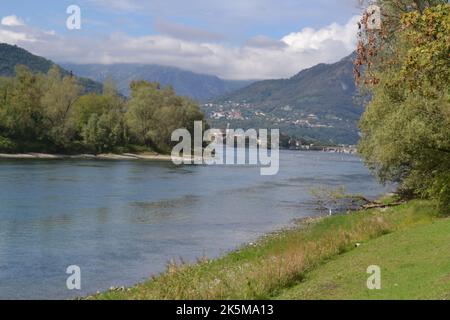 Schöne Sommerlandschaft des Flusses Adda breiten Kurs mit Bergen und großen grünen bewaldeten Park. Im Hintergrund die Stadt auf dem Hügel. Stockfoto