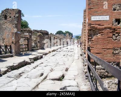 Gepflasterte Straße und Fußweg, mit Trittsteinen, um die Straße zu überqueren, um Exkremente und Wasser zu vermeiden, in einer Straße in Pompeji, Italien Stockfoto