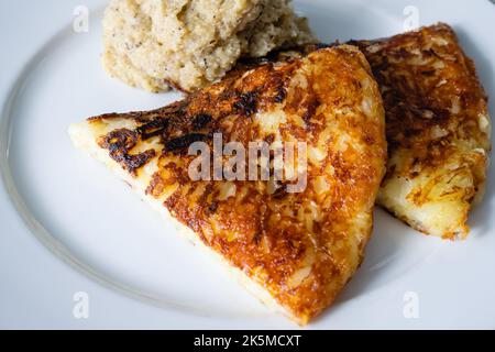 Frico Friulano Italienischer Montasio Käse und Kartoffelrosti mit Polenta ein traditionelles Gericht aus der Region Friaul in Italien Stockfoto