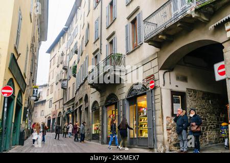 Shopper-Spaziergang durch die gepflasterten Straßen der Citta Alta, Bergamo, Italien Stockfoto