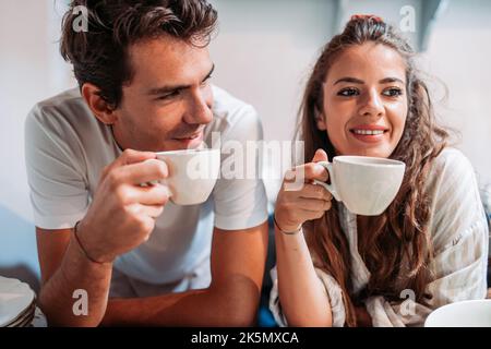 Das junge Paar trinkt morgens einen Kaffee Stockfoto