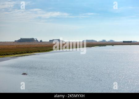 Wässrige Landschaft mit ehemaligen Atomwaffenforschungslabors am Horizont, Orford Ness, Suffolk Stockfoto