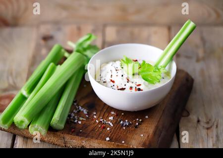 Sellerie-Sticks mit weißer Sauce in einer Schüssel. Gesunde Ernährung. Stockfoto