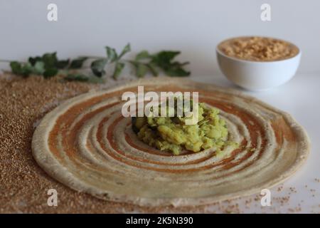 Kodo Hirse Masala dosa. Dünne knusprige Crepes aus kodo-Hirse- und Linsenmehl, gefüllt mit gewürzten Kartoffelpüree. Aufgenommen auf weißem Hintergrund. Stockfoto