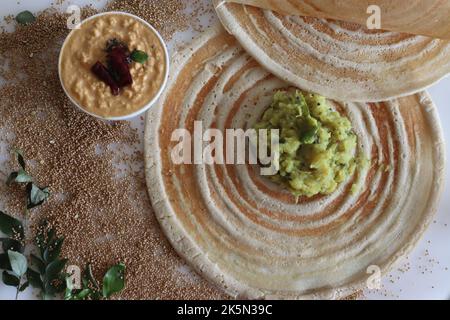 Kodo Hirse Masala dosa. Dünne knusprige Crepes aus kodo-Hirse- und Linsenmehl, gefüllt mit gewürzten Kartoffelpüree. Aufgenommen auf weißem Hintergrund. Stockfoto