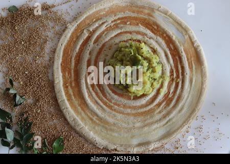 Kodo Hirse Masala dosa. Dünne knusprige Crepes aus kodo-Hirse- und Linsenmehl, gefüllt mit gewürzten Kartoffelpüree. Aufgenommen auf weißem Hintergrund. Stockfoto