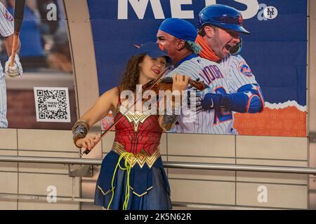 NEW YORK, NEW YORK - 08. OKTOBER: Eine Frau, die als Wonder Woman gekleidet ist, spielt während der New York Comic Con 2022 am 08. Oktober 2022 in New York City an der U-Bahn-Station Hudson Yards Geige. Kredit: Ron Adar/Alamy Live Nachrichten Stockfoto