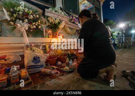 Uthai Sawan, Nong Bua Lamphu, Thailand. 9. Oktober 2022, Uthai Sawan, Nong Bua Lamphu, Thailand: Eine Frau betet vor einem Denkmal vor dem Wat Rat Samakee in der Provinz Nong Bua Lamphu, Thailand, während der Trauerrituale für die Opfer der Tragödie. Ein Angreifer benutzte eine Kombination aus Gewehren und Messern, um mindestens 35 Menschen in der Kindertagesstätte zu töten, wobei die meisten der Opfer kleine Kinder waren. Kredit: ZUMA Press, Inc./Alamy Live Nachrichten Stockfoto