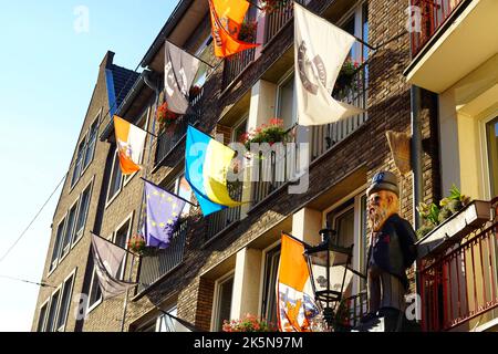 Vor einem Restaurant in der Düsseldorfer Altstadt stehen verschiedene lokale und internationale Flaggen. Stockfoto