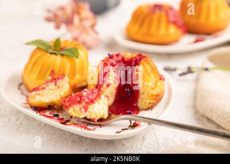 Grießkäsekuchen mit Erdbeermarmelade, Lavendel, Tasse Kaffee auf grauem Beton-Hintergrund und Leinentextilien. Seitenansicht, Nahaufnahme, selektiver Fokus. Stockfoto