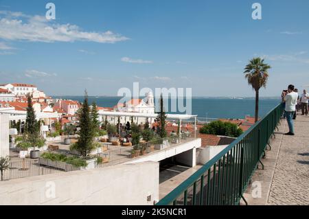 Blick auf die Dächer von Lissabon und den Fluss Tejo vom Miradouro das Portos do Sol (Platz der Sonnengore) - mit Fotografen Stockfoto