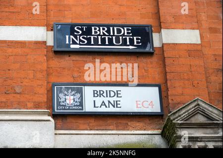 LONDON - 21. Mai 2022: St Bride Institute und Bride Lane Straßenschilder für C4 Dollar auf der Seite des roten Backsteingebäudes Stockfoto