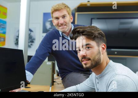 Zwei Bildschirmgerätungstechniker posieren Stockfoto