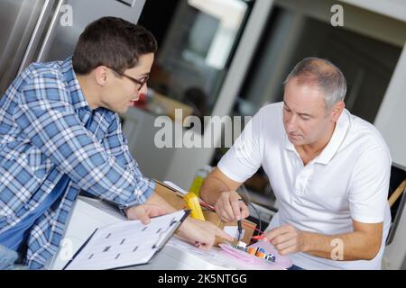 Zwei Arbeiter an elektrischen Stromkreisen Stockfoto