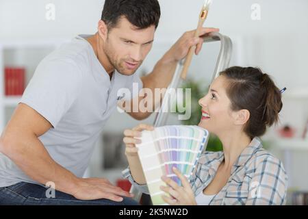 Junges Paar mit einem Farbmuster isoliert auf weißem Hintergrund Stockfoto