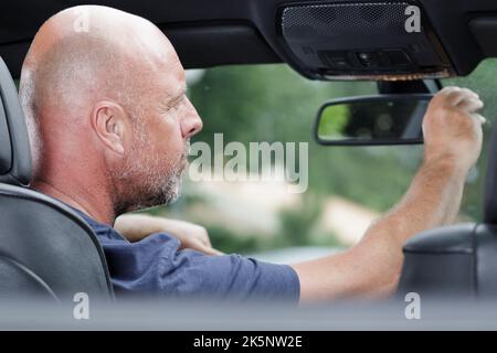 mans Hand Einstellung des Rückspiegels im Auto Stockfoto