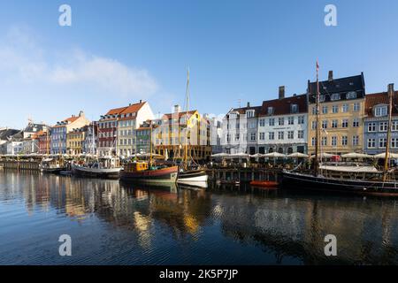 Kopenhagen, Dänemark. Oktober 2022. Die bunten Häuser des 17.. Und 18.. Jahrhunderts auf dem Nyhavn-Kanal, mit Holzbooten im Stadtzentrum Stockfoto