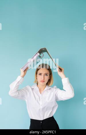 Harte Arbeit. Müde Frau. Viele Aufgaben. Vermeiden Sie das Problem. Traurige Dame im Büro aussehen halten Ordner unter dem Kopf wie Dach isoliert blau. Stockfoto