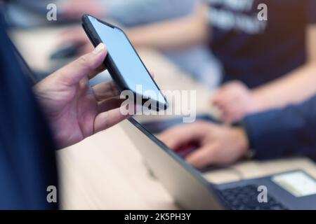 Das Konferenzpersonal scannt bei der Ankunft einen QR-Code des Teilnehmers zur Abferungsstelle Stockfoto