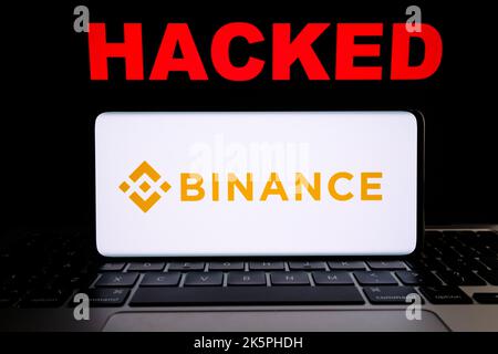 Binance-Kryptoaustausch gehackt. Binance-Logo auf Smartphne und roter Text „GEHACKT“ auf Laptop. Konzept. Stafford, Großbritannien, 9. Oktober 202 Stockfoto