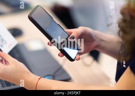 Das Konferenzpersonal scannt bei der Ankunft einen QR-Code des Teilnehmers zur Abferungsstelle Stockfoto