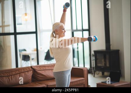 Fröhliche Frau, die eine Krafttraining-Übung macht Stockfoto