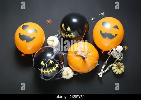 Komposition mit Halloween Ballons, Kürbissen und Netz auf dunklem Hintergrund Stockfoto