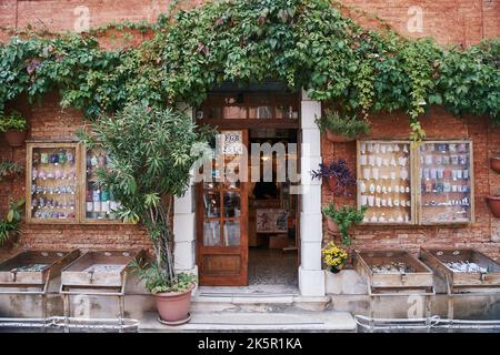 Venedig, Italien - 10.12.2021: Eingang zum Souvenirladen in Venedig. Holztür mit grünen Pflanzen um Stockfoto