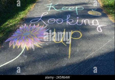 Eine aufmunternde Kreidekunst-Botschaft in unserer Auffahrt im Südwesten VON WI „Keep Looking up“ Stockfoto