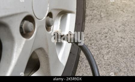 Das Einfüllen von Luft in die Autoreifen oder das Aufblasen von Reifen im selektiven Fokus Stockfoto
